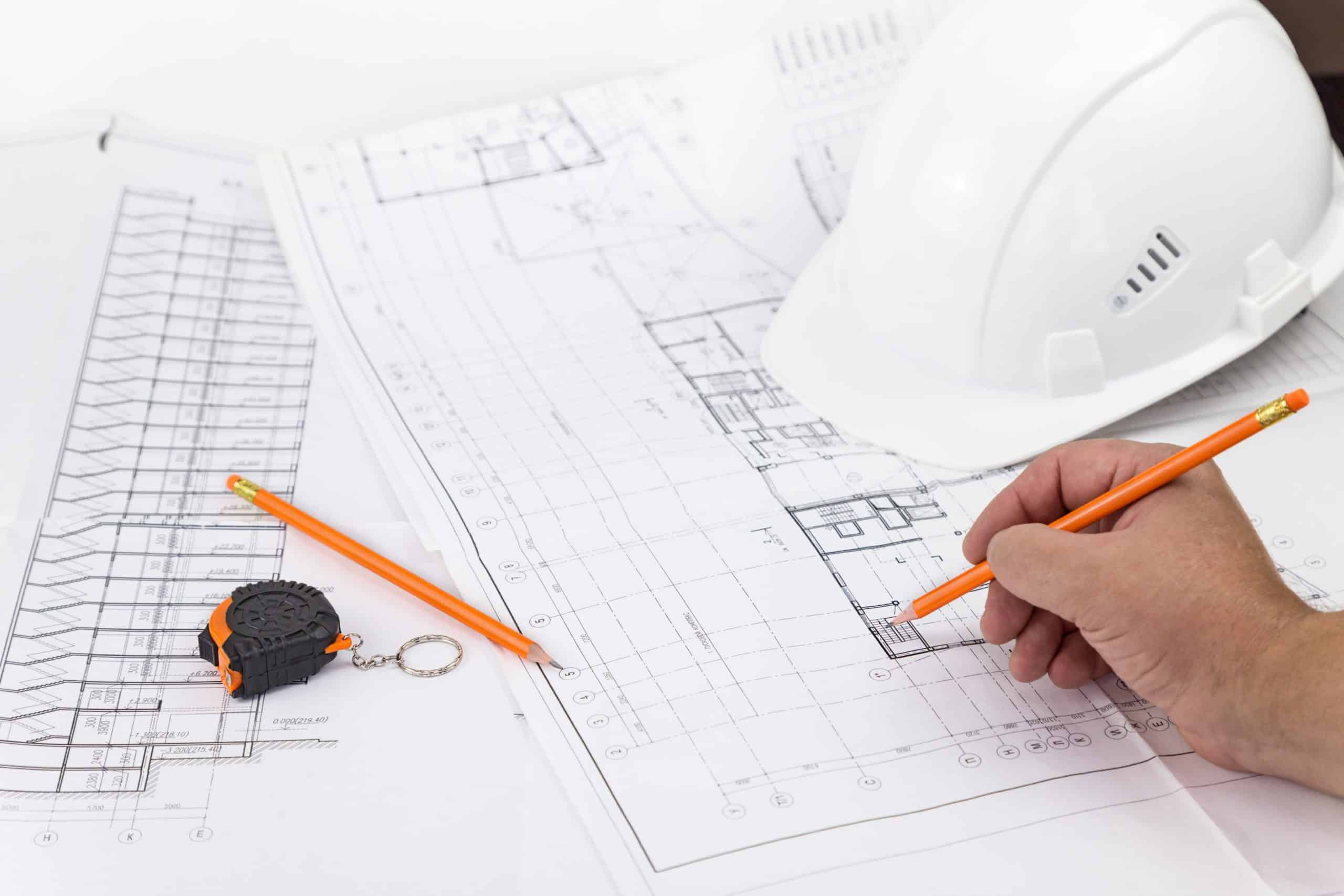 architect-working-on-blueprint-partner-working-drawings-indoors-man-light-measuring-structure-table_t20_RzOrPB